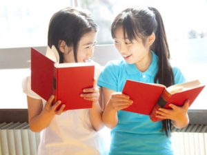 図書室で本を読む小学生女子